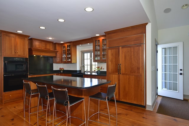 40 Shields Rd, Woodstock, CT 06281 - kitchen with brown cabinets, wood finished floors, recessed lighting, glass insert cabinets, and dark countertops