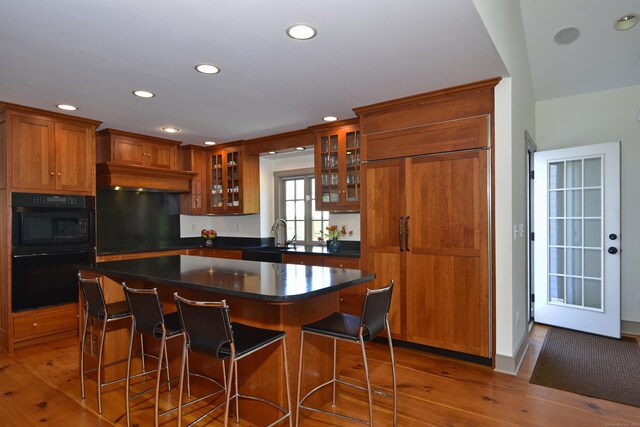 40 Shields Rd, Woodstock, CT 06281 - kitchen with brown cabinetry, wood finished floors, recessed lighting, glass insert cabinets, and dark countertops