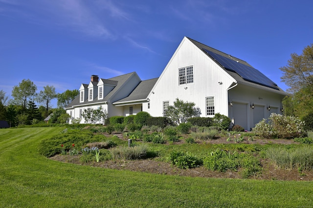 40 Shields Rd, Woodstock, CT 06281 - view of side of home featuring solar panels, a garage, a chimney, and a lawn