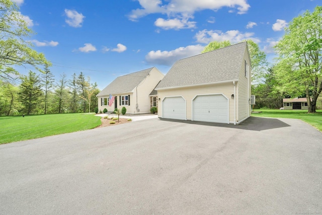 view of front facade featuring driveway, a garage, a front lawn, and a shingled roof