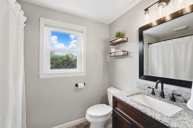 bathroom with baseboards, toilet, and vanity