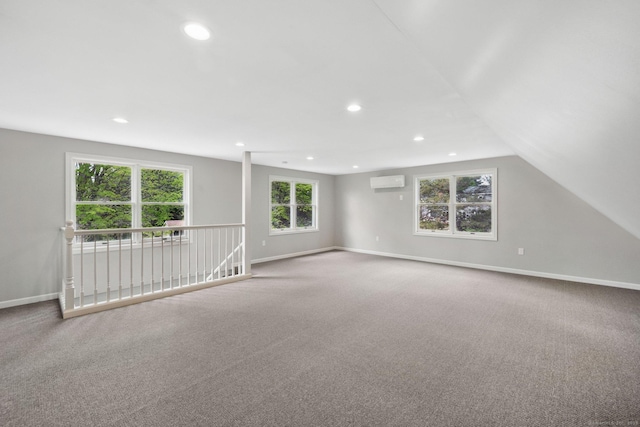carpeted spare room with recessed lighting, baseboards, and a wall unit AC