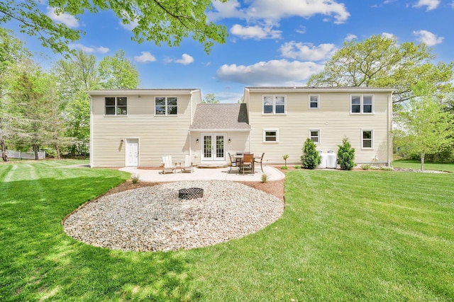 rear view of house with french doors, a patio, and a lawn