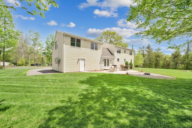 back of property featuring a patio area, a yard, and french doors
