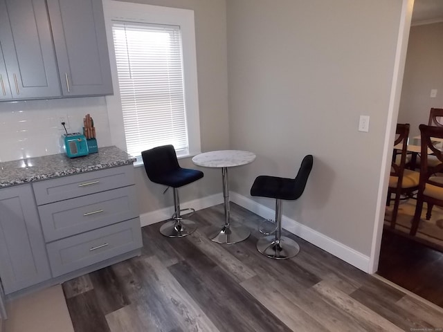 dining space featuring dark wood-type flooring and baseboards