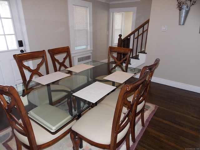 dining area featuring baseboards, wood finished floors, and stairs