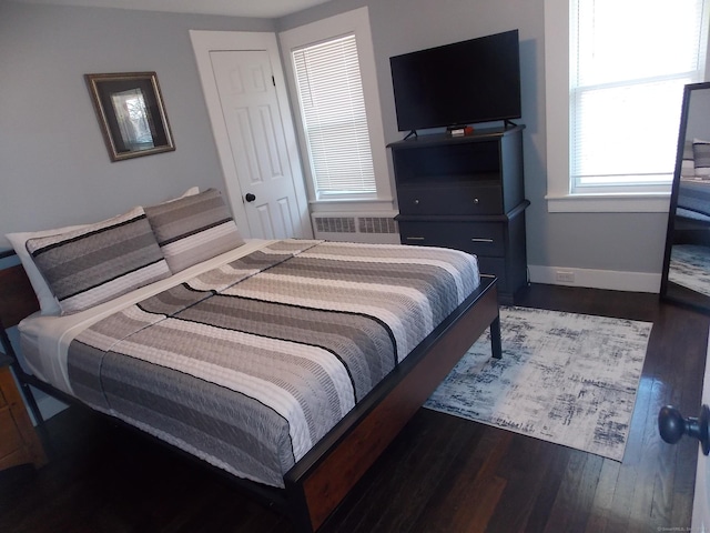 bedroom with baseboards and dark wood-type flooring