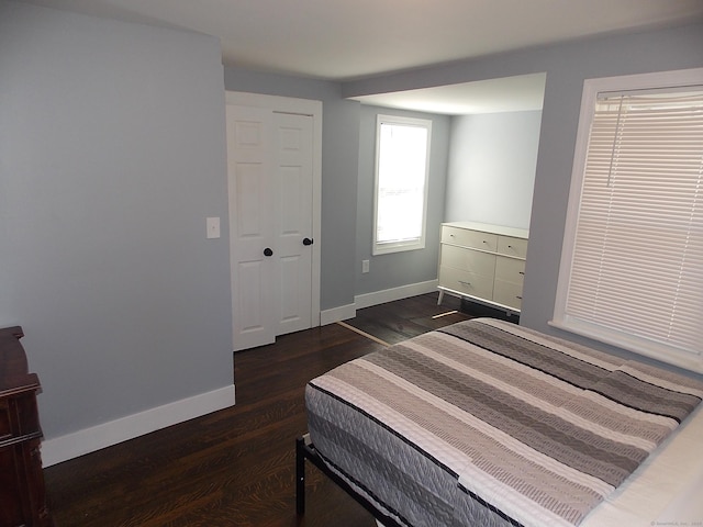 bedroom with baseboards and dark wood-style floors