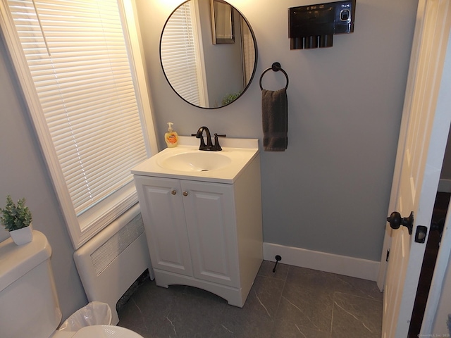 bathroom featuring baseboards, toilet, and vanity