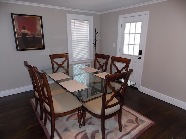 dining room featuring baseboards, wood finished floors, and crown molding