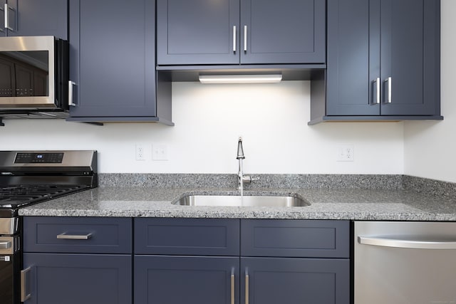 25 Oakwood Cir Unit 7, Plainville, CT 06062 - kitchen featuring light stone counters, appliances with stainless steel finishes, a sink, and blue cabinets