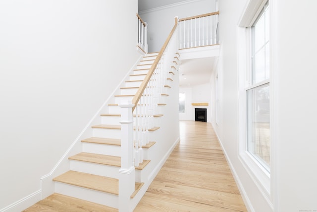 25 Oakwood Cir Unit 7, Plainville, CT 06062 - stairway featuring a towering ceiling, wood finished floors, a wealth of natural light, and a fireplace