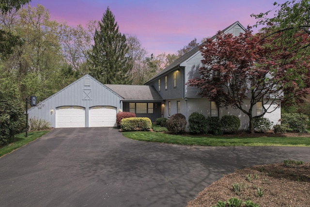 view of front of home featuring brick siding, a garage, and aphalt driveway