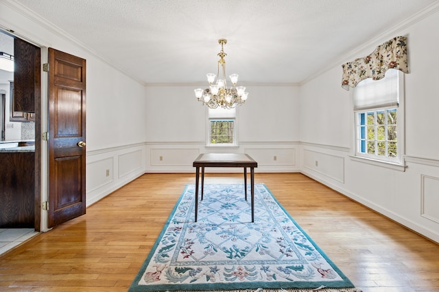 32 Woodmont Rd, Avon, CT 06001 - unfurnished dining area featuring healthy amount of natural light, crown molding, light wood finished floors, a chandelier, and a wainscoted wall