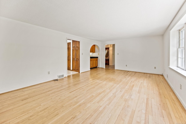 32 Woodmont Rd, Avon, CT 06001 - unfurnished living room with arched walkways, light wood-type flooring, and baseboards