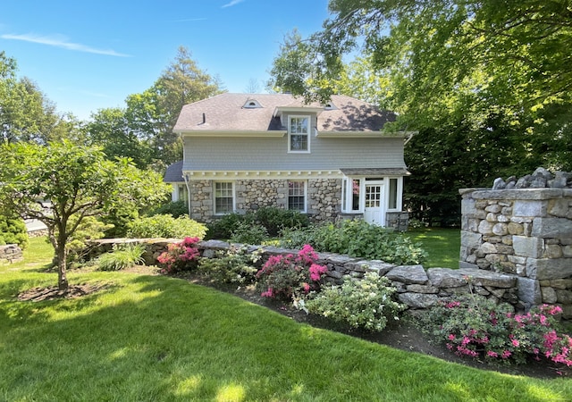 back of house featuring a yard and stone siding