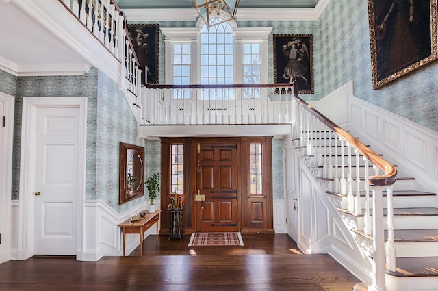 foyer entrance with hardwood / wood-style flooring, a wealth of natural light, a wainscoted wall, and wallpapered walls