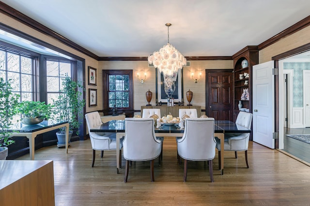 dining area with crown molding, a notable chandelier, and hardwood / wood-style floors