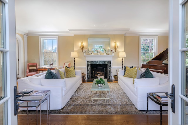 living area featuring a fireplace, crown molding, and wood finished floors