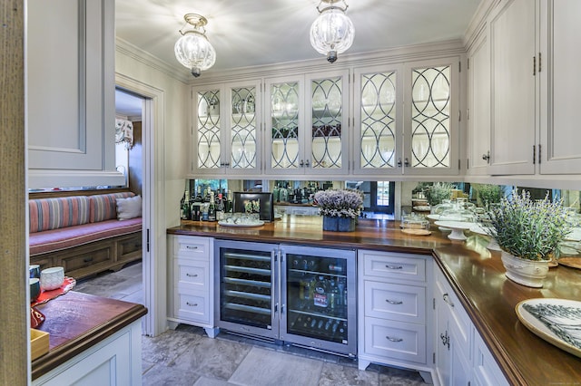 bar featuring crown molding, a bar, and beverage cooler