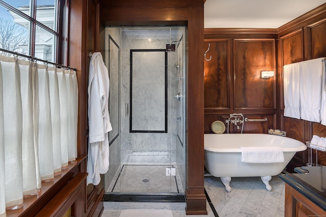full bathroom with a shower stall and a freestanding bath