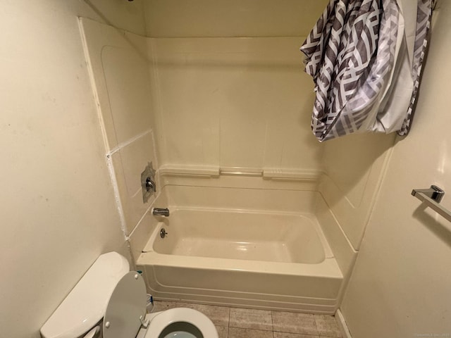 bathroom featuring toilet, washtub / shower combination, and tile patterned flooring