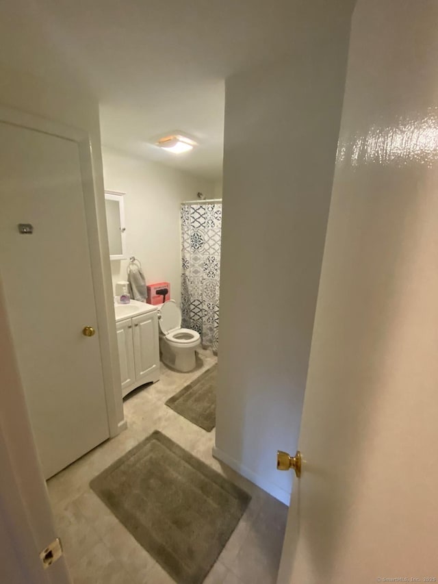 bathroom with a shower with shower curtain, baseboards, toilet, and vanity