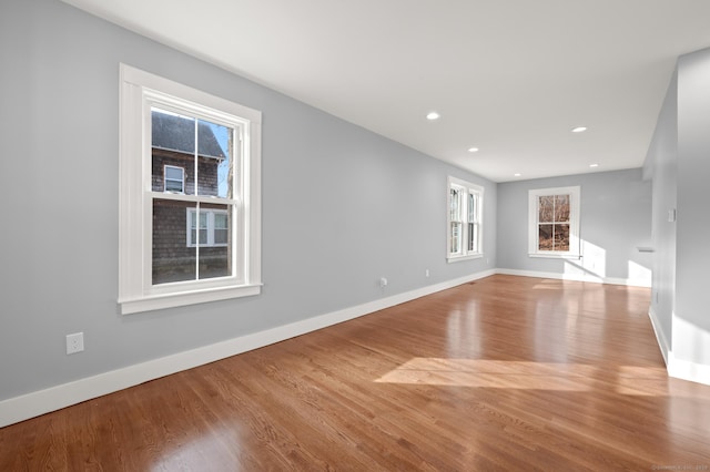 unfurnished living room with baseboards, recessed lighting, and wood finished floors