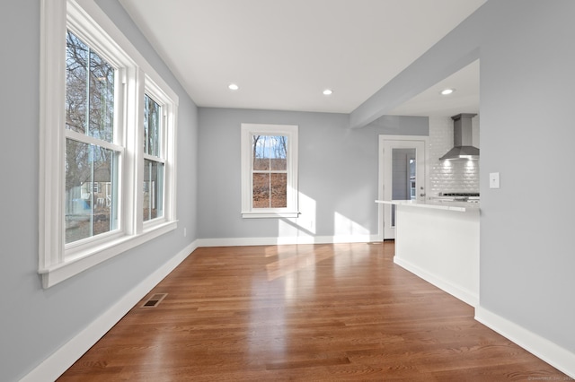 unfurnished living room featuring visible vents, baseboards, recessed lighting, and wood finished floors
