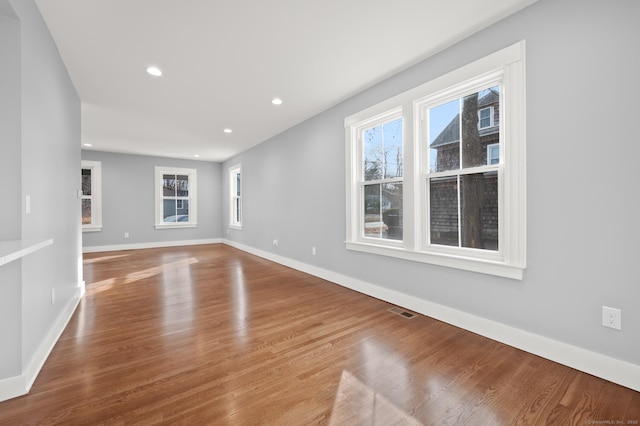 empty room with recessed lighting, visible vents, baseboards, and wood finished floors