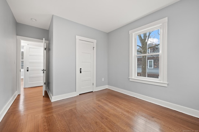 unfurnished bedroom with wood finished floors and baseboards