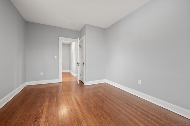 empty room featuring wood finished floors and baseboards