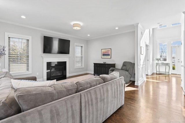 living room featuring dark wood-style floors, visible vents, baseboards, and ornamental molding