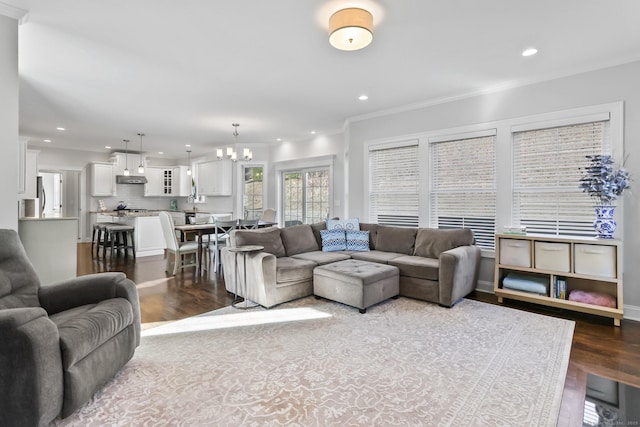 living room with ornamental molding, dark wood finished floors, recessed lighting, baseboards, and a chandelier