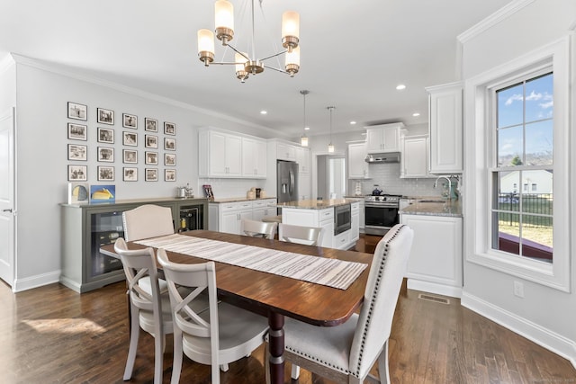 dining space with dark wood-style floors, baseboards, visible vents, crown molding, and a chandelier