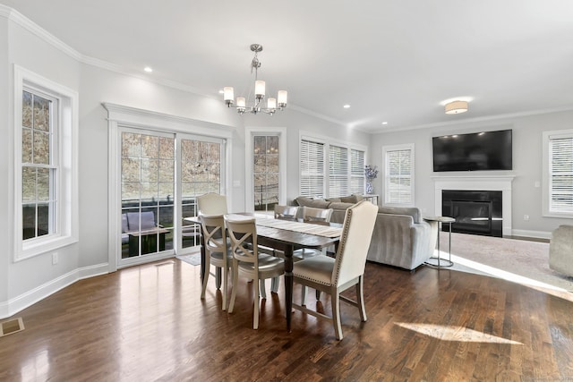 dining room featuring dark wood-style floors, a glass covered fireplace, baseboards, and an inviting chandelier