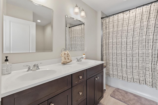 bathroom featuring double vanity, shower / tub combo, and a sink