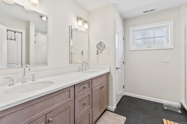 bathroom with a sink, visible vents, baseboards, and double vanity