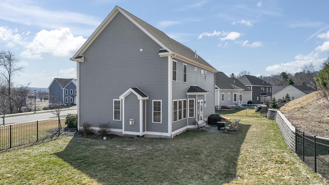 rear view of property featuring a patio, a lawn, and a fenced backyard