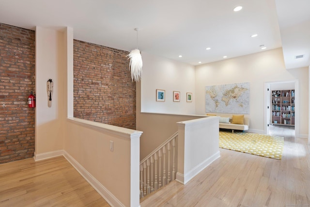 93 Elm St, Hartford, CT 06106 - corridor featuring visible vents, wood finished floors, an upstairs landing, and brick wall