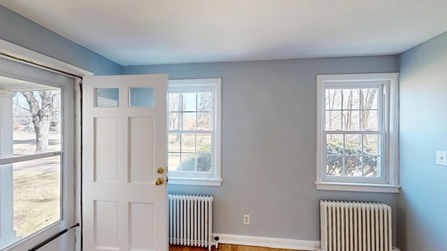 foyer entrance with radiator heating unit and baseboards