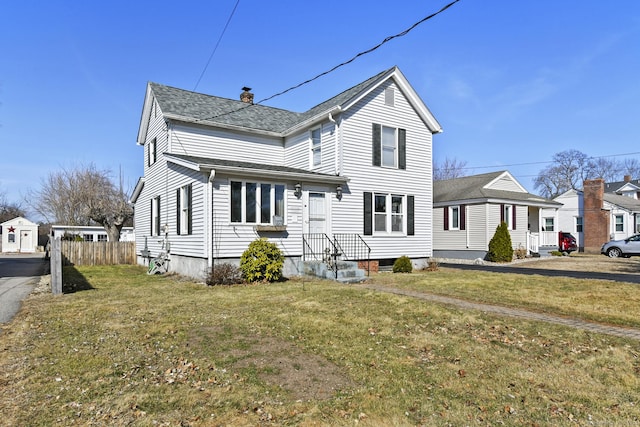 rear view of property featuring a lawn, a chimney, and fence