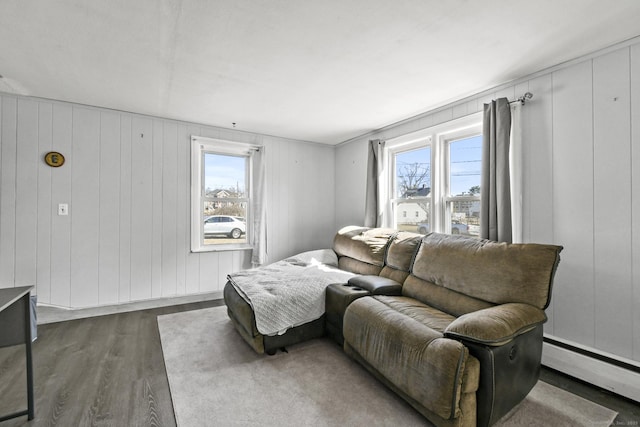 living room with a wealth of natural light, baseboard heating, and dark wood-style floors