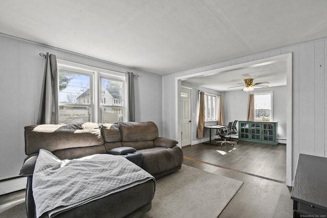 living area with ceiling fan, a baseboard radiator, and wood finished floors