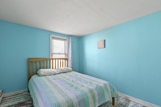 bedroom with a baseboard radiator and baseboards