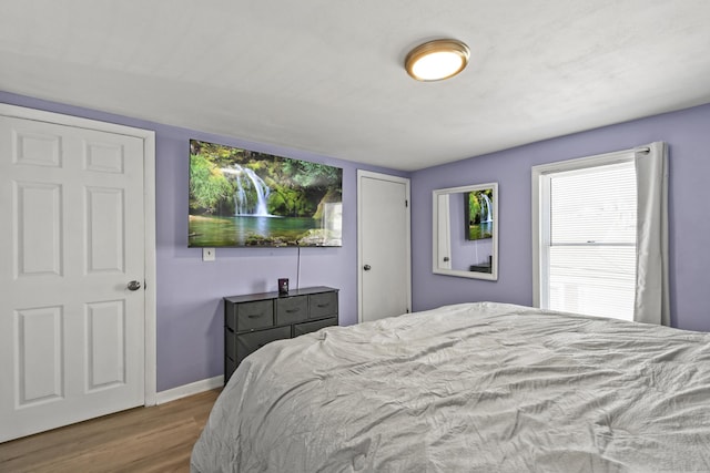 bedroom with wood finished floors and baseboards