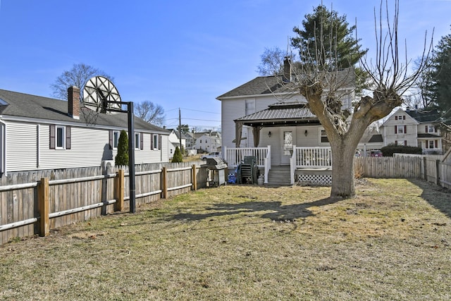 back of house with a yard, a residential view, a fenced backyard, and a shingled roof