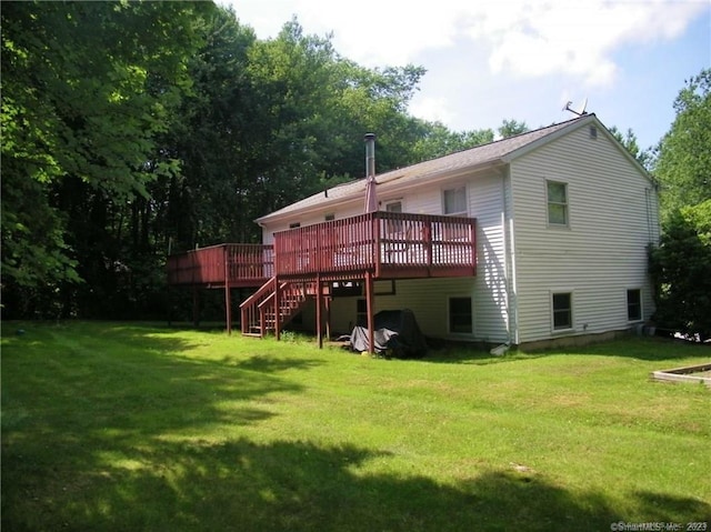 back of house with a deck, stairway, and a lawn