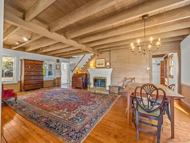 5 Old Pawson Rd, Branford, CT 06405 - living area with wooden walls, an inviting chandelier, beam ceiling, wood-type flooring, and wooden ceiling