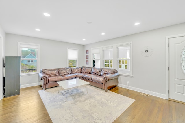 living room featuring recessed lighting, light wood-type flooring, baseboards, and visible vents